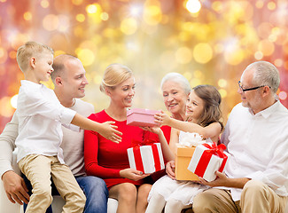 Image showing happy family with christmas gifts over lights