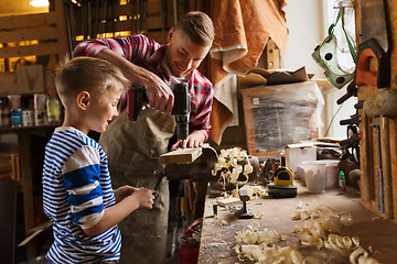 Image showing father and son with drill working at workshop