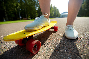 Image showing close up of female feet riding short skateboard