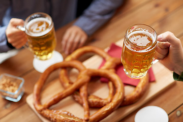 Image showing close up of hands with beer mugs at bar or pub