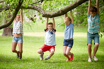 Image showing happy kids hanging on tree in summer park