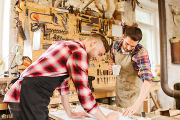 Image showing carpenters with ruler and blueprint at workshop