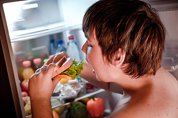 Image showing Hungry man holding a sandwich in his hands and standing next to 