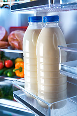 Image showing Bottles of milk in the fridge