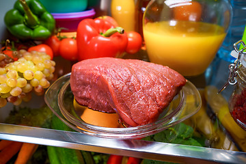 Image showing Fresh raw meat on a shelf open refrigerator