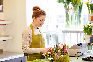 Image showing smiling florist woman making bunch at flower shop