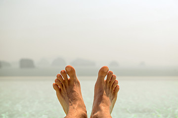 Image showing closeup of male feet over sea and sky on beach