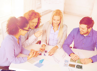 Image showing smiling creative team looking at sketch