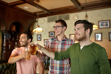 Image showing happy male friends drinking beer at bar or pub