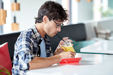 Image showing man with notebook and juice writing at cafe