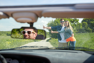 Image showing couple hitchhiking and stopping car on countryside