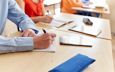 Image showing close up of student writing to notebook at school