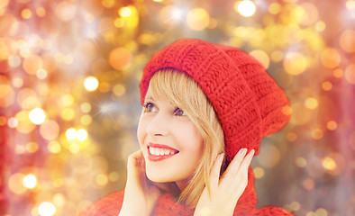 Image showing happy woman in winter hat and scarf over lights