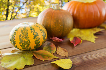 Image showing close up of pumpkins on wooden table outdoors