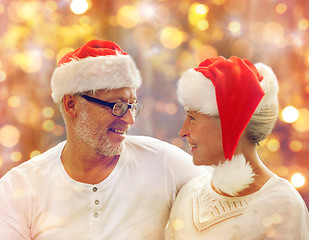 Image showing happy senior couple in santa helper hats