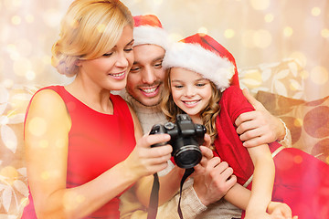 Image showing family in santa helper hats looking at pictires