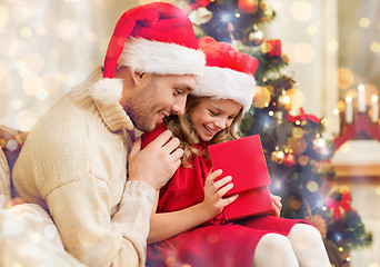 Image showing smiling father and daughter opening gift box