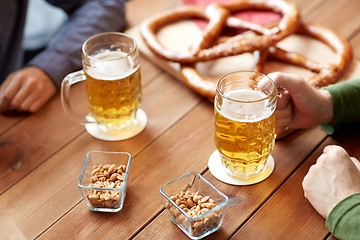 Image showing close up of hands with beer mugs at bar or pub