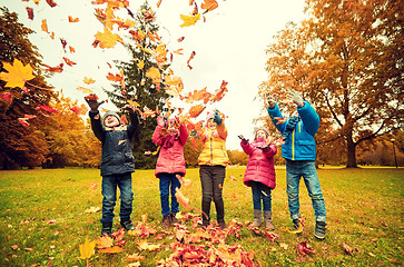 Image showing happy children playing with autumn leaves in park