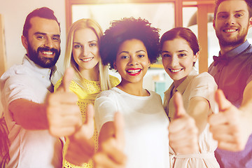 Image showing happy creative team showing thumbs up in office