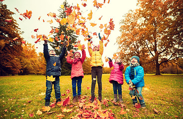 Image showing happy children playing with autumn leaves in park