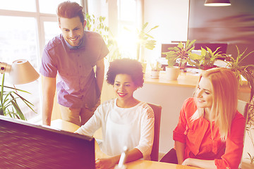 Image showing happy creative team with computer in office