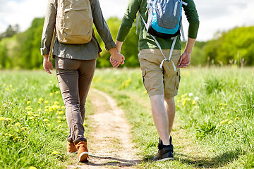 Image showing close up of couple with backpacks walking on road