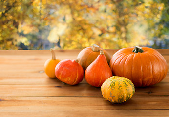 Image showing close up of pumpkins on wooden table outdoors