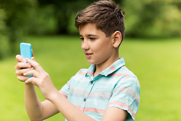 Image showing boy with smartphone playing game in summer park