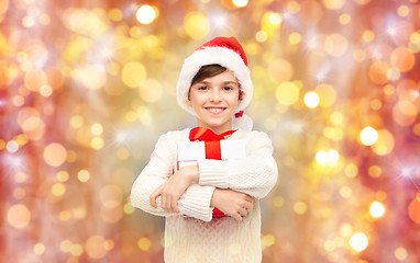 Image showing smiling happy boy in santa hat with gift box