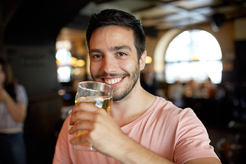 Image showing close up of happy man drinking beer at bar or pub