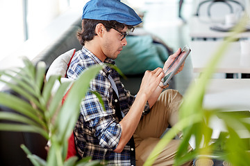 Image showing man with tablet pc sitting at cafe table