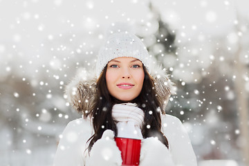 Image showing happy young woman with tea cup outdoors in winter