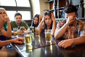 Image showing friends with beer watching football at bar or pub