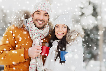 Image showing happy couple with tea cups over winter landscape