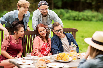 Image showing happy friends having dinner at summer garden party