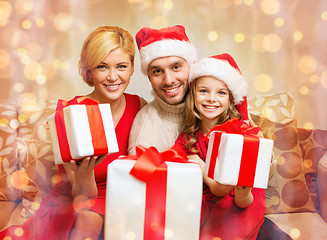 Image showing smiling family giving many gift boxes