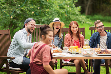 Image showing happy friends having dinner at summer garden party