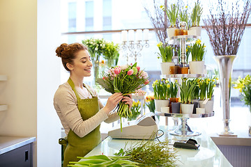 Image showing smiling florist woman making bunch at flower shop