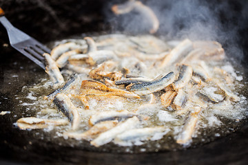 Image showing close up of fried fish in pan at street market