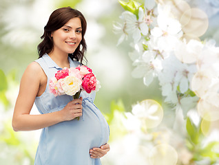 Image showing happy pregnant woman with flowers touching belly