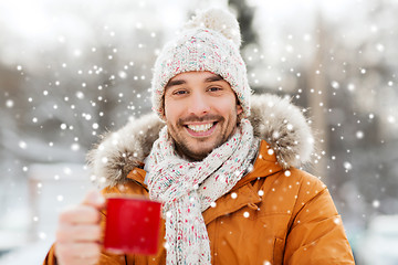 Image showing happy man with tea cup outdoors in winter