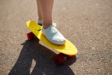 Image showing close up of female feet riding short skateboard