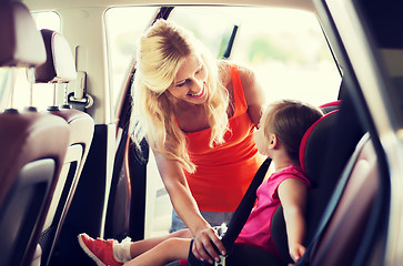 Image showing happy mother fastening child with car seat belt