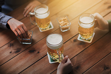 Image showing close up of hands with beer mugs at bar or pub