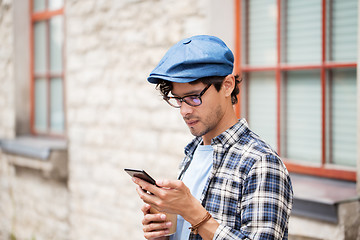 Image showing man with smartphone drinking coffee on city street