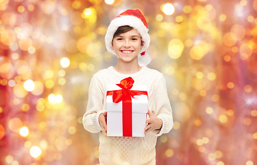 Image showing smiling happy boy in santa hat with gift box