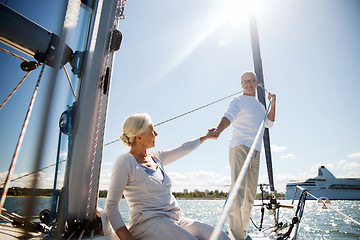 Image showing happy senior couple on sail boat or yacht in sea