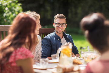 Image showing happy friends having dinner at summer garden party