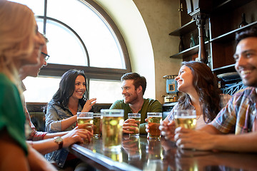 Image showing happy friends drinking beer at bar or pub